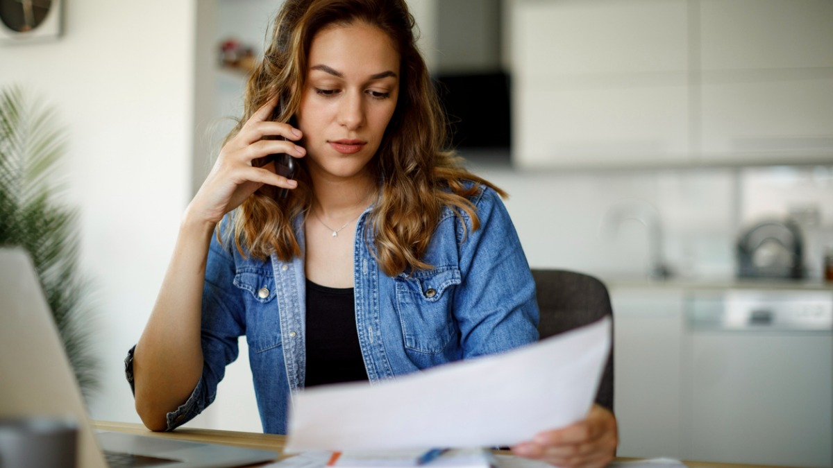 femme au telephone qui regarde sa facture d'energie